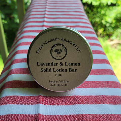 Lavender & Lemon Solid Lotion Bar container on a striped fabric background