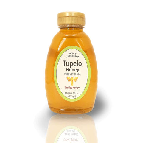 A jar of Tupelo Honey with a label indicating it is raw and unfiltered, produced by Smiley Honey, LLC, with a net weight of 2 oz (56 g).