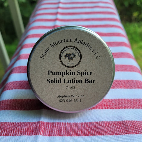 Pumpkin Spice Solid Lotion Bar container on a striped fabric background