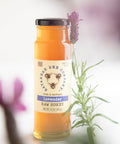 Jar of lavender raw honey with a lavender flower in the background