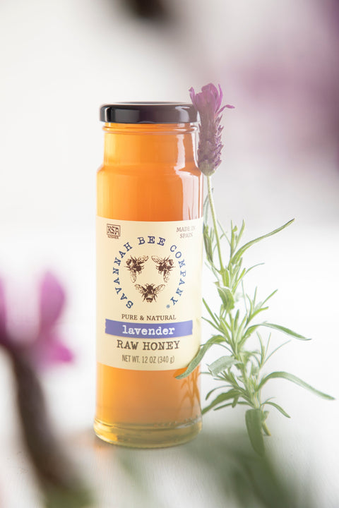 Jar of lavender raw honey with a lavender flower in the background