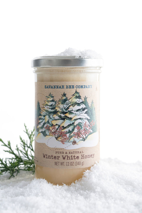Savannah Bee Company winter white honey jar with snowy landscape label on a white background