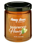 A jar of Basswood Honey with a label that includes the brand name and the type of honey. The jar is filled with golden-colored honey.