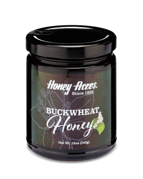 A 12 oz. jar of Buckwheat Honey with a label that includes the brand name and the type of honey. The jar is sealed with a black lid.