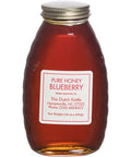 Jar of pure blueberry honey with a label on a white background