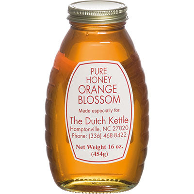 Jar of pure honey with a label on a white background