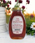 Bottle of pure honey wildflower with a label on a natural background