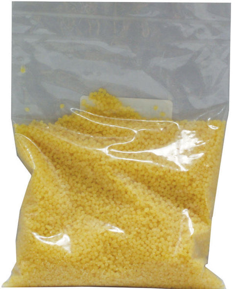 A clear plastic bag filled with yellow beeswax pellets.