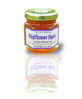 Jar of wildflower honey with a visible label on a white background