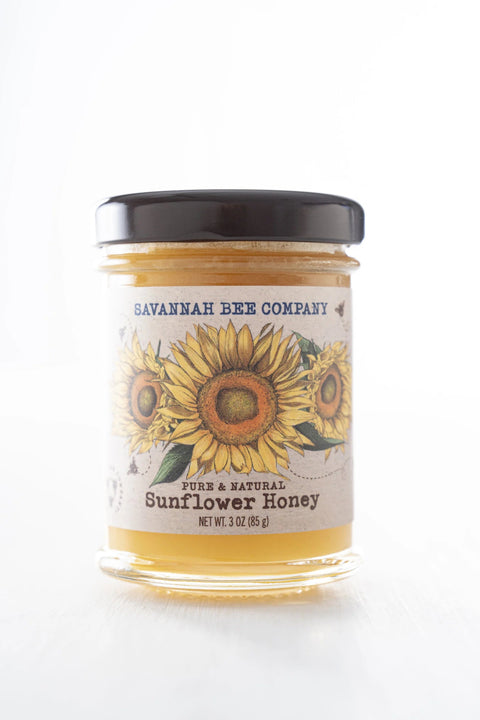 Jar of Savannah Bee Company sunflower honey with a sunflower design on the label.