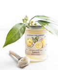 Savannah Bee Company lemon candle with green leaves and flowers on a white background