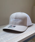 Beige cap with 'Foxadise Farms' logo on a wooden surface