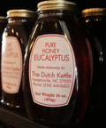 Jars of pure honey labeled as Eucalyptus honey, with the brand name 'The Dutch Kettle' and contact information.