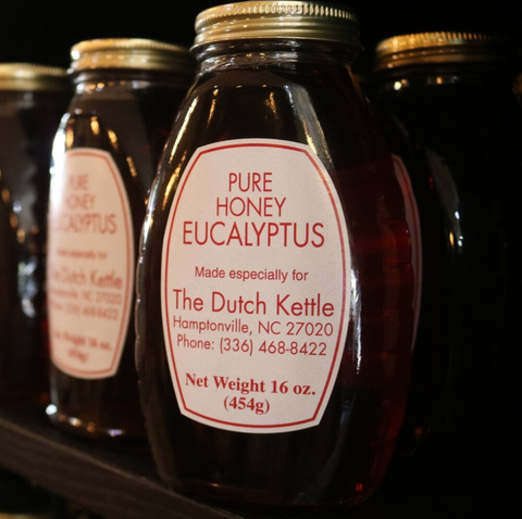 Jars of pure honey labeled as Eucalyptus honey, with the brand name 'The Dutch Kettle' and contact information.