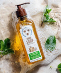 


Hand soap bottle with pump dispenser on a soapy surface with mint leaves