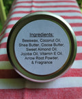 Jar lid with ingredient list on a red and white striped fabric background