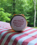 Honey container with text on a striped fabric background outdoors