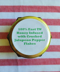 Honey container lid with text on a striped fabric background