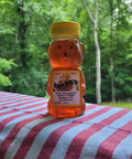 Honey bear container on a striped tablecloth with a forest background