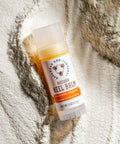 Heel balm stick on a textured beige background