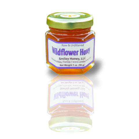 A jar of Wildflower Honey with a label indicating it is raw and unfiltered, produced by Smiley Honey, LLC.