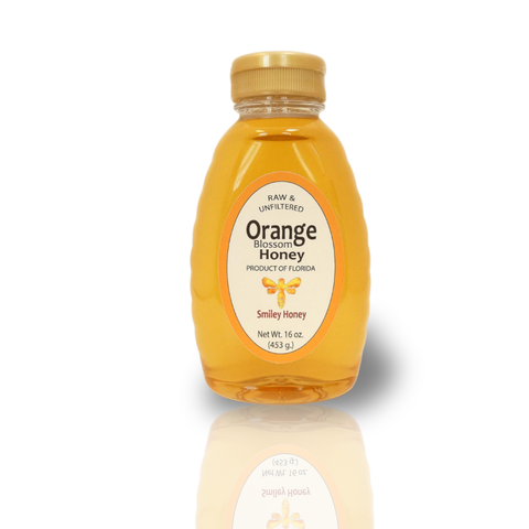 A jar of pure orange blossom honey from The Dutch Kettle, with a label indicating the product name and the weight of 16 oz.