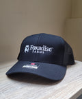 Navy blue cap with 'Foxadise Farms' logo on a wooden surface