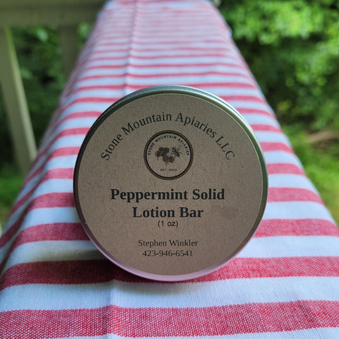 Peppermint solid lotion bar on a striped tablecloth outdoors