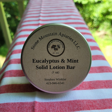 Eucalyptus & Mint Solid Lotion Bar by Stone Mountain Apiaries LLC on a red and white striped fabric background.