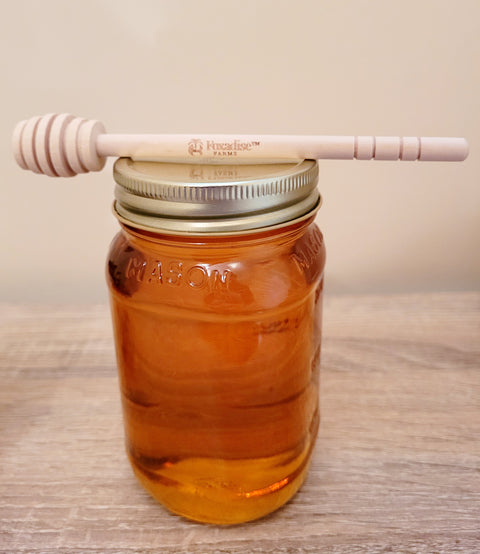 Mason jar filled with honey on a wooden surface
