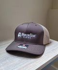 Brown and beige cap with 'Foxadise Farms' logo on a wooden surface.
