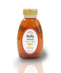 A jar of Holly Honey placed on a table with a red checkered tablecloth, with a background of greenery.