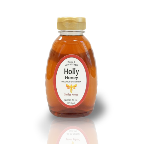 A jar of Holly Honey placed on a table with a red checkered tablecloth, with a background of greenery.