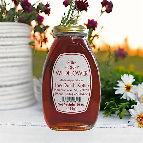 A jar of Wildflower Honey with a label indicating it is raw and unfiltered, produced by Smiley Honey, LLC.