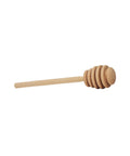 A wooden honey dipper with a series of round honeycomb-shaped rings at the end.