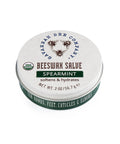 A tin container of Beeswax Salve with Spearmint. The label shows the brand name, product name, and a partial image of a bee.